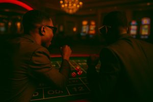 Back view of two men observing a Sic Bo table, symbolising focus and discipline in advanced Sic Bo strategy