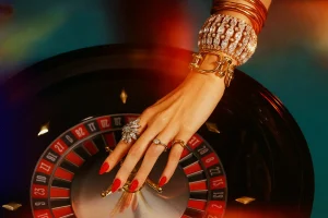 Luxury roulette strategy moment with woman’s jeweled hand above spinning wheel